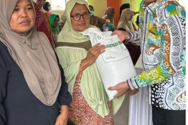 Sekda Rustam Serahkan Bantuan Pangan Beras untuk 1.088 KPM di Pasar Sukadana